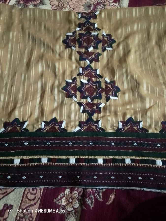 Golden fabric with maroon star embroidery and hem border