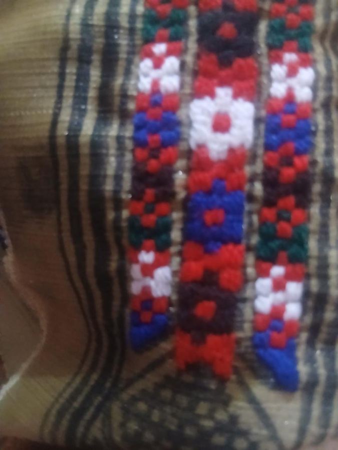 Close-up of colourful hand embroidery being stitched over a printed pattern